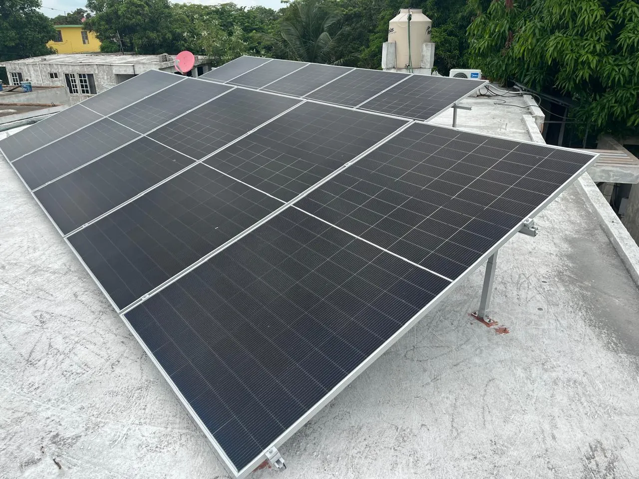 Sistema solar instalado en un techo de concreto, junto a un tinaco de agua